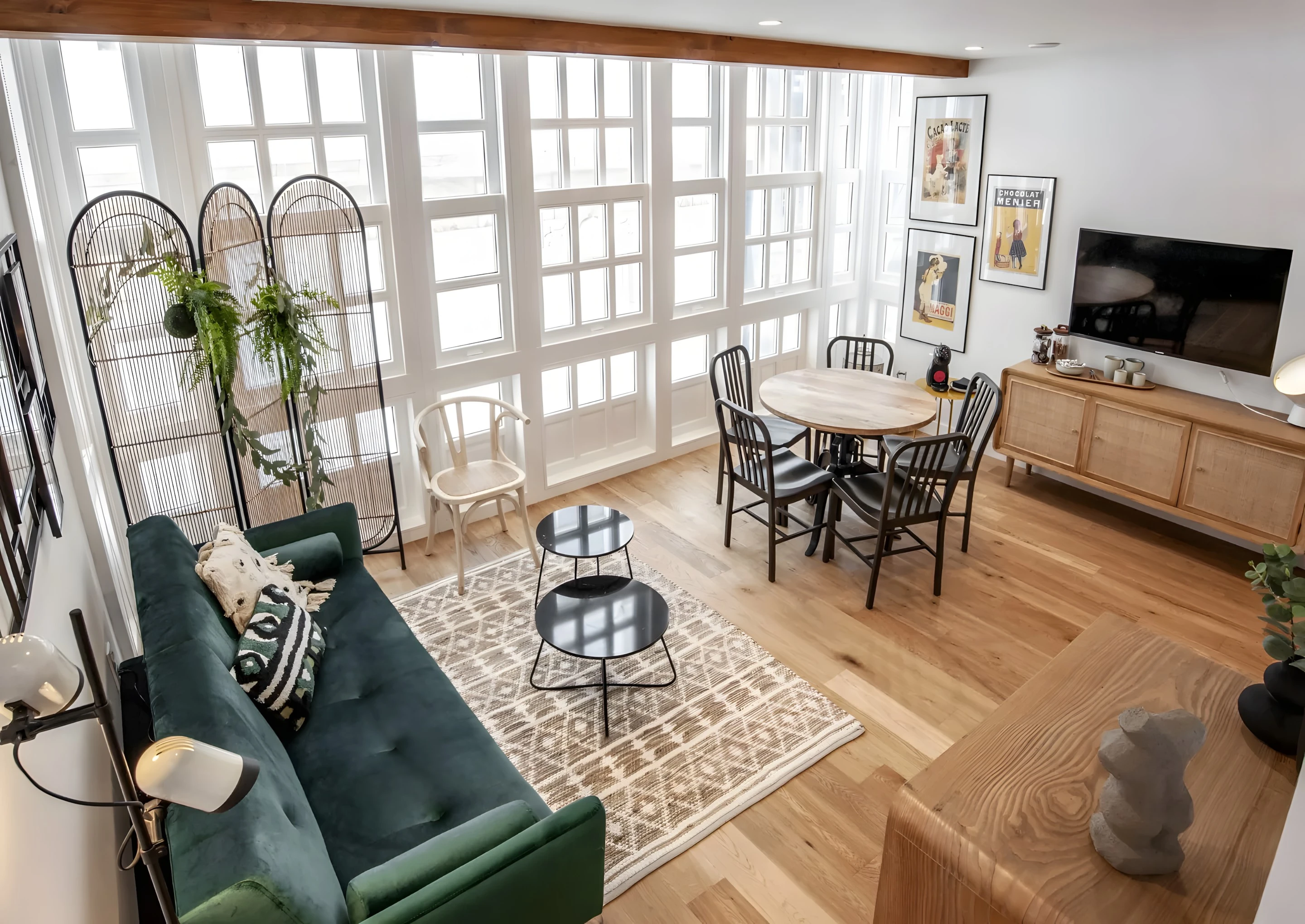 Salón con galería acristalada y sofá verde