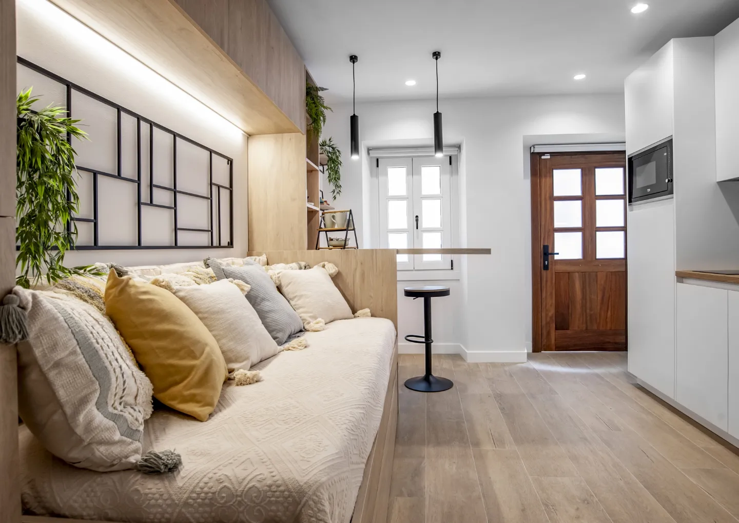 El sofá-nicho de madera integra almacenaje e iluminación