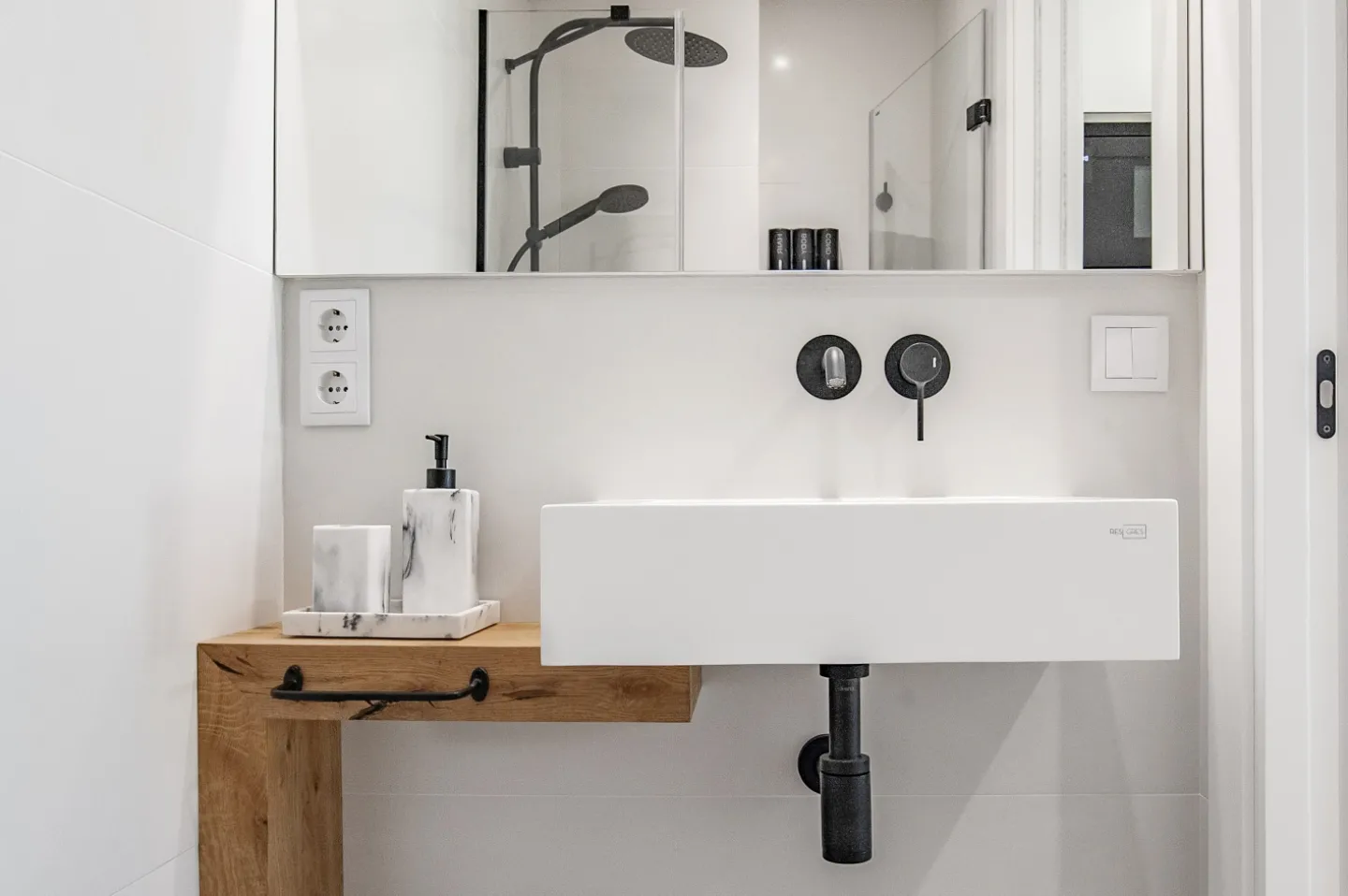 El baño, resuelto en blanco, negro y roble