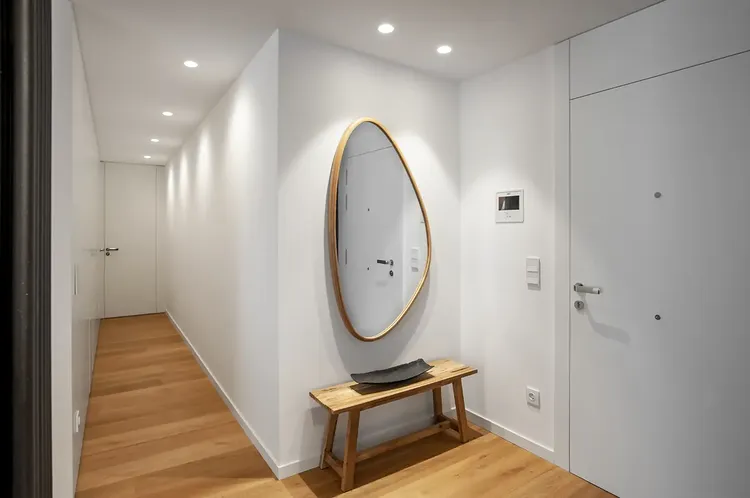 El recibidor: un espejo orgánico y un banco de madera