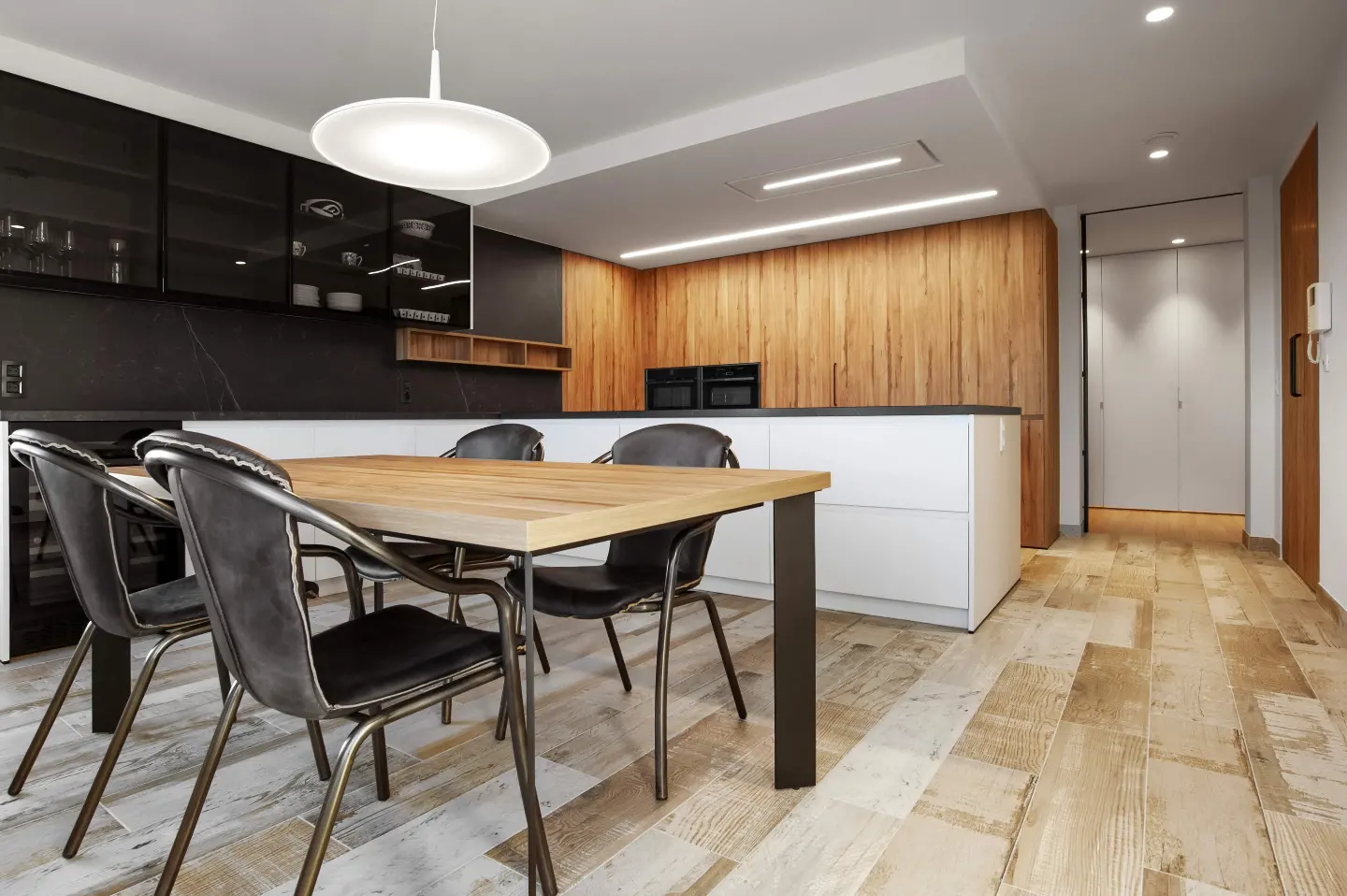 Cocina de madera con isla blanca y comedor integrado