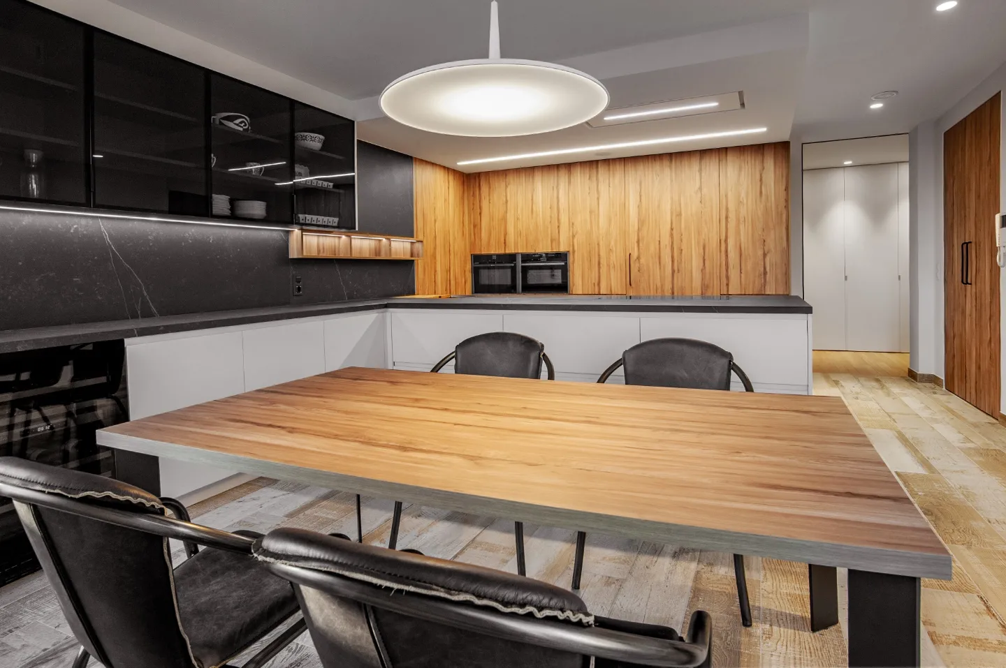 La cocina con frentes de madera y negro mate, junto a la mesa de comedor