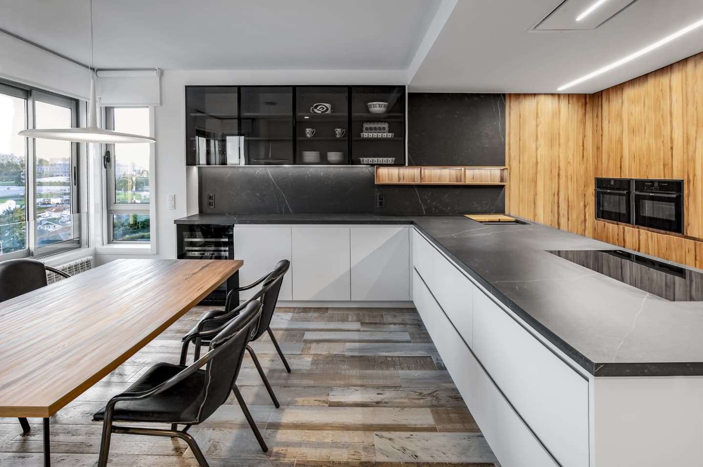 La cocina, entre piedra oscura y madera, abierta a las vistas de la ciudad