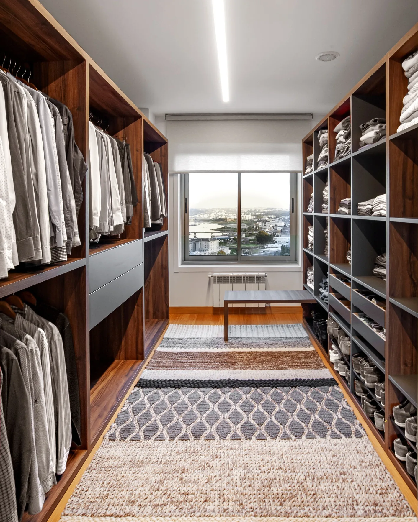 El vestidor principal, en nogal y gris, con ventana sobre la ría